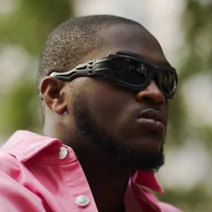 Futuristic wrap-around punk sunglasses in matte black finish worn by a male model