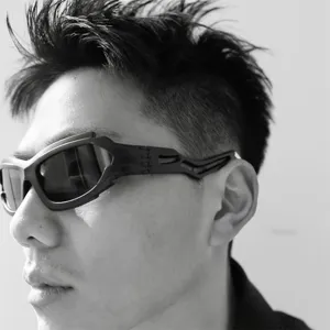 Close-up of futuristic punk sunglasses with irregular black frames worn by a model