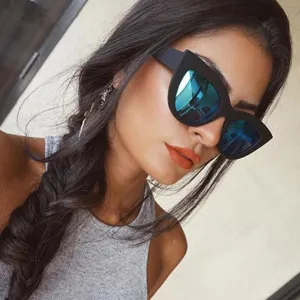 Stylish model wearing vintage black cat eye sunglasses with blue mirrored lenses