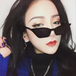 Close-up of stylish black small-frame cat-eye sunglasses worn by a female model