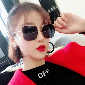 Close-up of trendy square metal sunglasses with gold frames worn by an Asian model