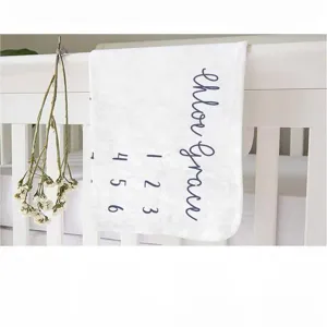 Soft personalized baby milestone blanket featuring cursive name and monthly growth numbers