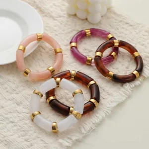 Détail de bracelets vintage en résine acrylique avec anneaux en métal doré, chic