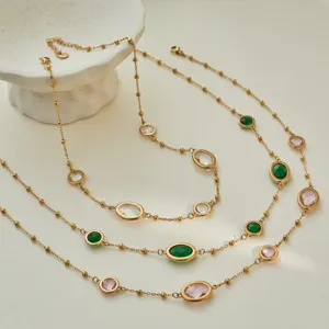 Detailed macro view of gold bead chain necklaces with bezel-set colorful gemstones