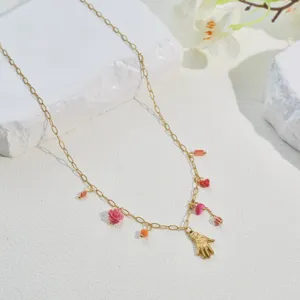 Detailed view of a gold stainless steel necklace with colorful floral and bead charms.