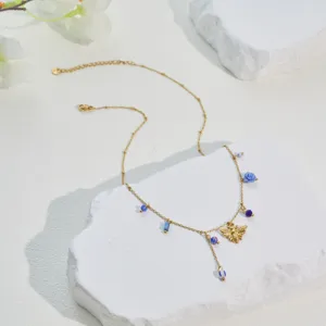 Gold-plated stainless steel necklace with honeybee and blue rose charms detail view