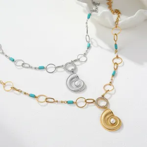 Close-up of stainless steel necklace with nautilus shell pendant and turquoise beads
