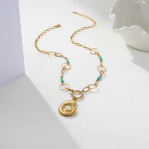 Detail view of ocean shell pendant with pearl and turquoise beads on gold chain.