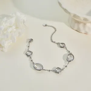 Detalle de una elegante pulsera plateada con gemas facetadas transparentes engastadas.