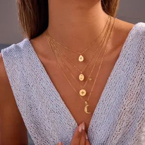 Collar de acero inoxidable dorado a capas con dijes de estrella y luna en modelo