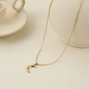Detalle de cerca de un collar de media luna dorada con acentos de estrellas brillantes.