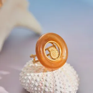 Λεπτομέρεια δαχτυλιδιού από χρυσό 18K με σχέδιο κοχύλι και ρητίνη σε κεχριμπάρι.