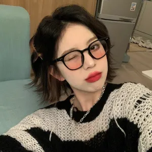 Fashionable black frame glasses featuring pink blush lenses worn by a young woman