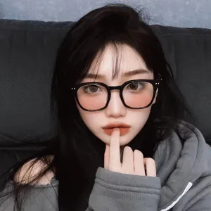 Close-up view of a model wearing stylish black oversized glasses with pink blush tinted lenses