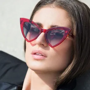 Vue détaillée d'un mannequin portant des lunettes de soleil œil-de-chat rouges rétro.
