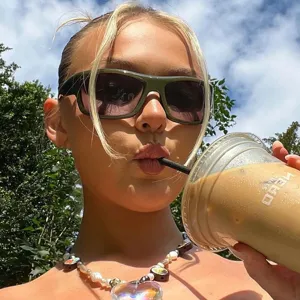 Outdoor lifestyle shot of a model wearing green Y2K wrap-around sports sunglasses