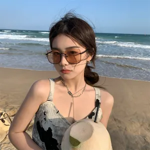 Stylish tea-colored large frame sunglasses for women on a sunny beach lifestyle