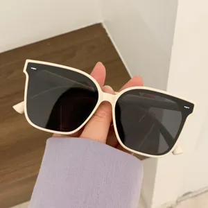 Close-up of stylish oversized cream sunglasses with chic rice nail decor
