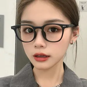 Asian female model wearing retro black square frames with rice nail detail accents
