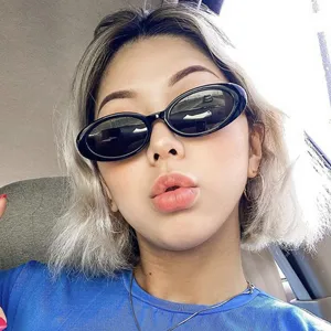 Femme élégante portant des lunettes de soleil ovales noires rétro au style coréen