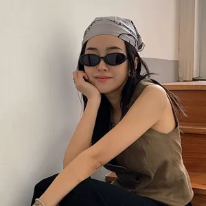 Mannequin asiatique portant des lunettes de soleil ovales noires rétro et un gilet marron