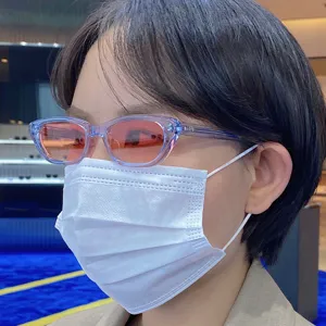 Detail view of Korean style small frame sunglasses with transparent blue frame and gradient lenses.