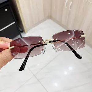 Close-up of rimless sunglasses with purple gradient lenses and gold metal frame.