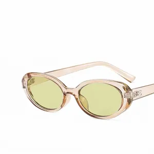 Lunettes de soleil ovales rétro avec monture champagne transparente et verres jaunes.