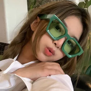 Gros plan d'un mannequin portant des lunettes de soleil carrées vertes vintage pour femmes