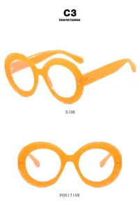 Vooraanzicht en zijaanzicht van oversized ronde oranje bril met metalen noppen details