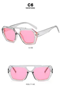 Trendy zonnebril met roze glazen en transparant grijs geometrisch montuur