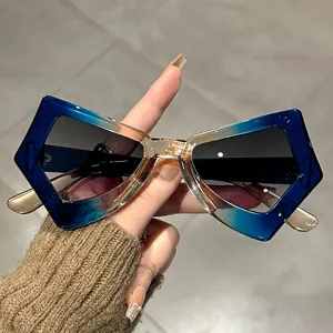 Close-up of vintage butterfly-shaped sunglasses with a blue and gold gradient frame