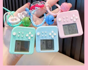 Detail of mini square Tetris game console keychain in pink, blue, and green colors.