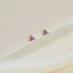 Close-up of triangle purple zircon stud earrings with gold stainless steel base