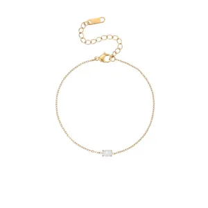 Close-up of a gold stainless steel bracelet with a dainty oval iridescent opal birthstone