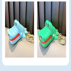Vista dettagliata dei portachiavi giocattolo coccodrillo dentista che morde le dita in blu e verde