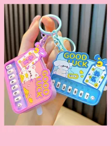 Close-up of pink and blue mini electronic piano toy keychains with cartoon characters