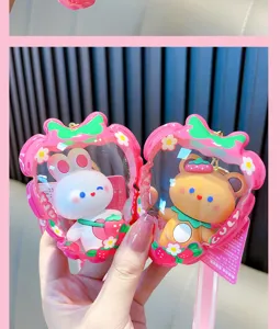 Detail view of cute rabbit and bear keychain charms in strawberry shaped pouches