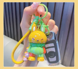 Close-up detail of a colorful dopamine silicone rabbit keychain held with car key.