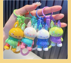 Close-up of four colorful dopamine-style rabbit keychains with glossy finish held by a hand