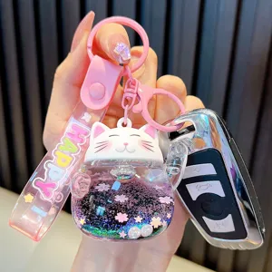 Cute liquid quicksand Maneki-neko keychain with pink strap and sparkling glitter charm.
