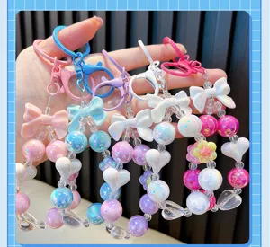 Detail showing colorful acrylic beaded keychains with cute bow and heart charm designs