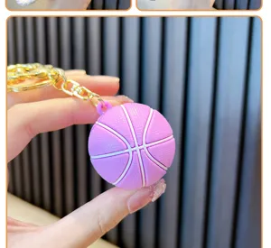 Dettaglio del portachiavi a forma di pallone da basket in gomma rosa e metallo oro