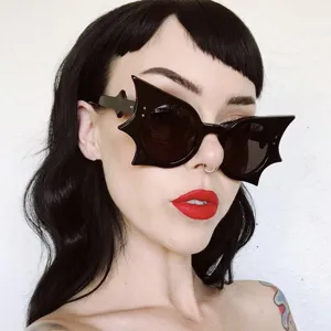 Close-up of stylish black bat-shaped sunglasses worn by a model for Halloween party costume