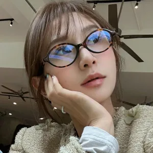 Close-up detail of retro tortoiseshell oval eyeglass frame worn by an Asian model