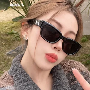 Gros plan de lunettes de soleil rectangulaires noires anti-UV portées par un mannequin