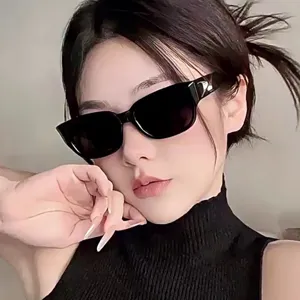 Gros plan d'une femme portant des lunettes de soleil carrées noires avec protection UV tendance.
