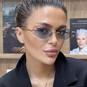 Detail view of rimless polygonal sunglasses featuring unique gold claw hinge
