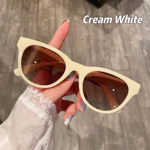 Primer plano de gafas de sol de ojo de gato retro blanco crema con lentes marrones