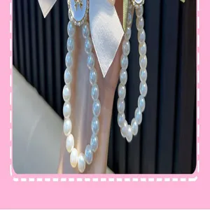 Close-up of handmade large pearl beaded keychain with elegant white ribbon bow